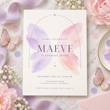 Watercolor wings invitation on a flat lay with pastel butterflies and flowers