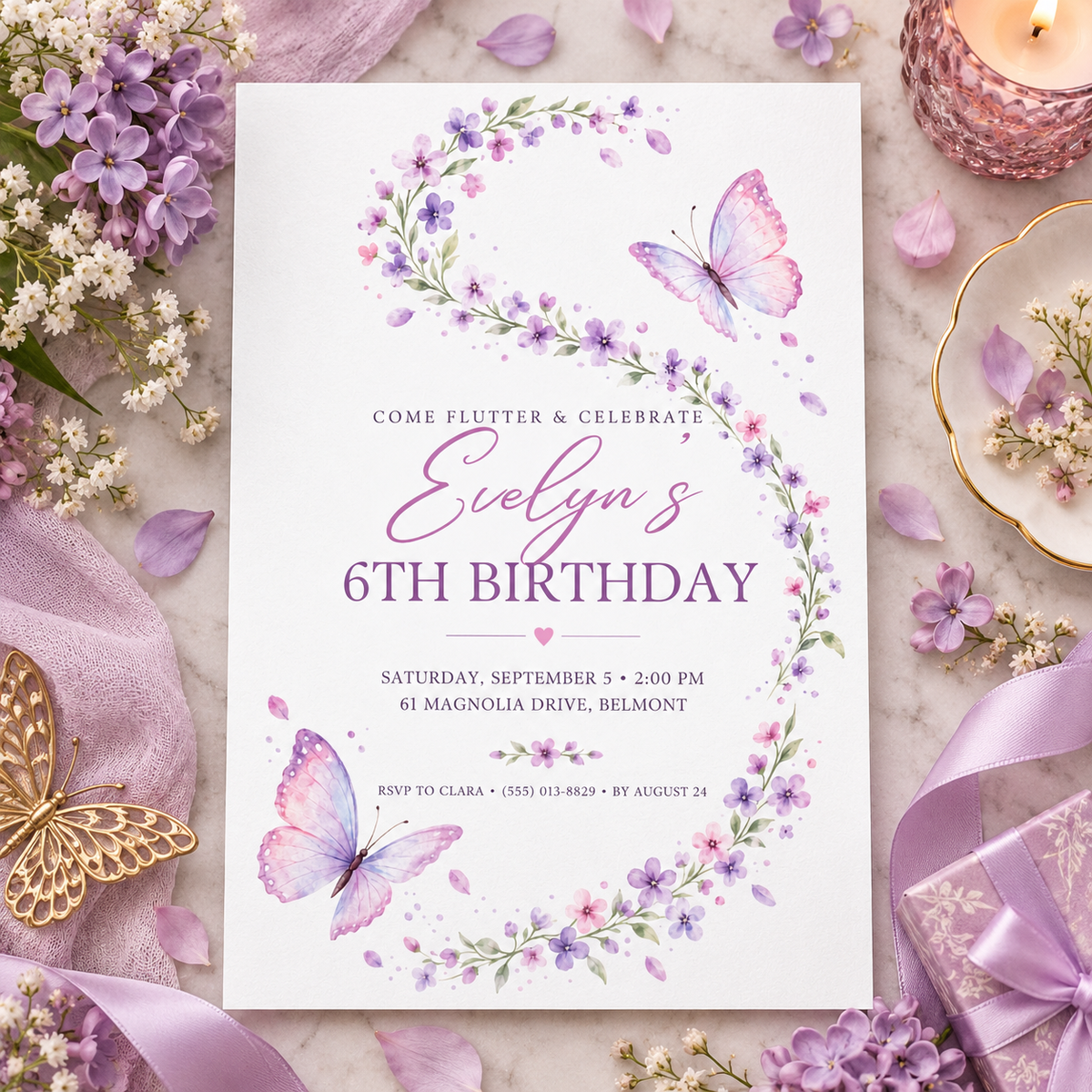 Lavender butterfly invitation on a flat lay with lilac flowers and ribbon
