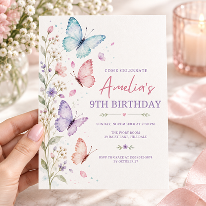 Hand holding a wildflower butterfly birthday invitation with watercolor flowers